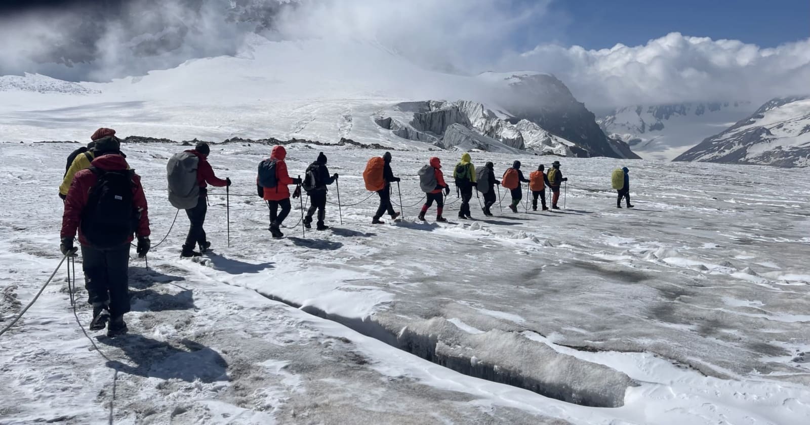 A group of trekkers walking on Khatling glacier below Auden's Col