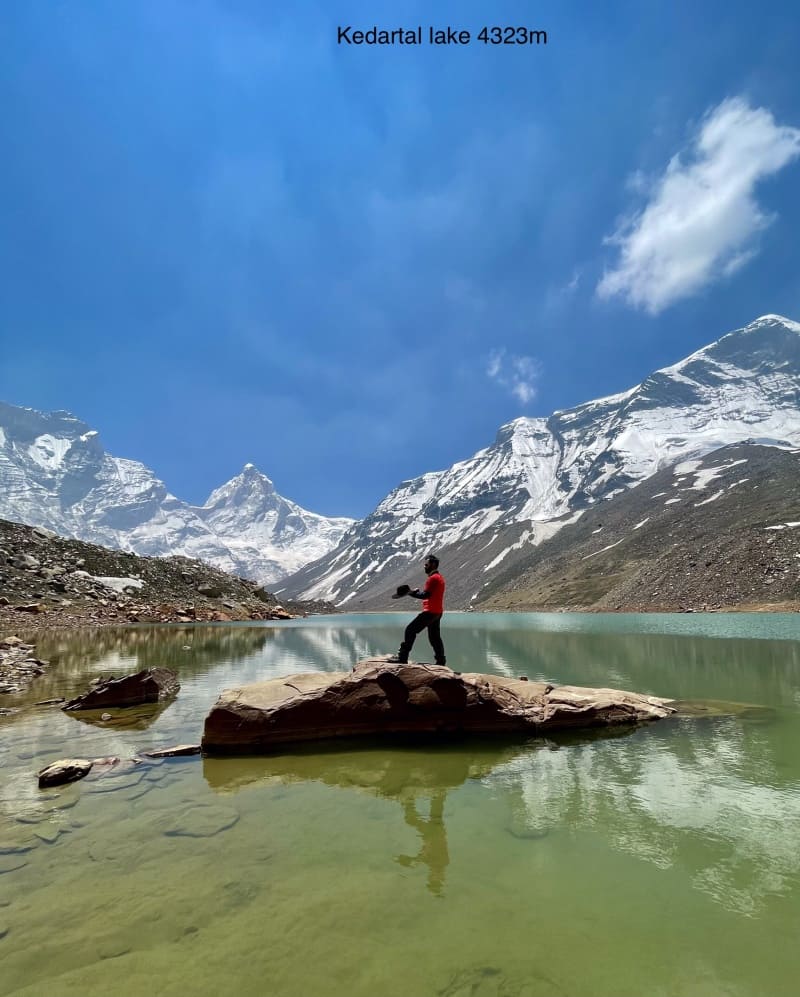 Hiker walking on boulder in middle of Kedartal lake