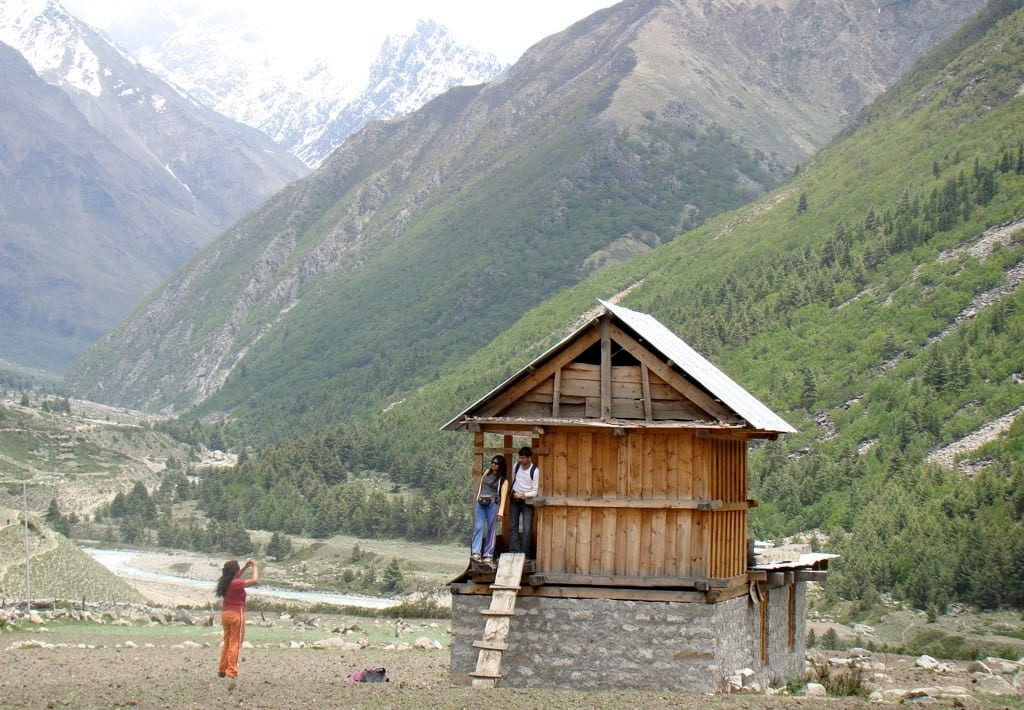 Taking photo at wooden granary store of a Chitkul household