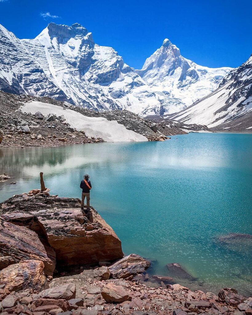 Hiker standing on a boulder by Kedartal lake